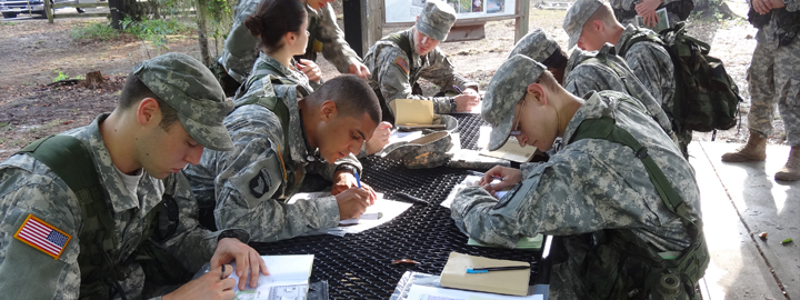 Soldiers sitting at a table doing an assignment