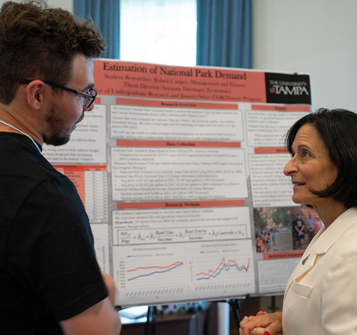 President Dahlberg talking with a student at a research presentation