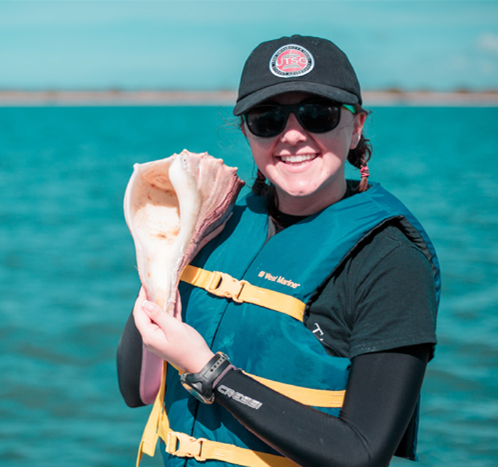 Marine Biology Student holding a conch shell Marine Biology Student holding a conch shell