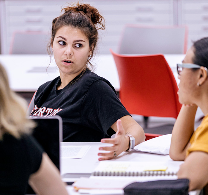 A table of students discussing policy. A table of students discussing policy.