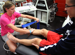 Student placing a band on another student's foot Student placing a band on another student's foot