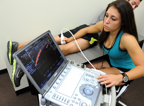Student doing an ultrasound of a leg Student doing an ultrasound of a leg