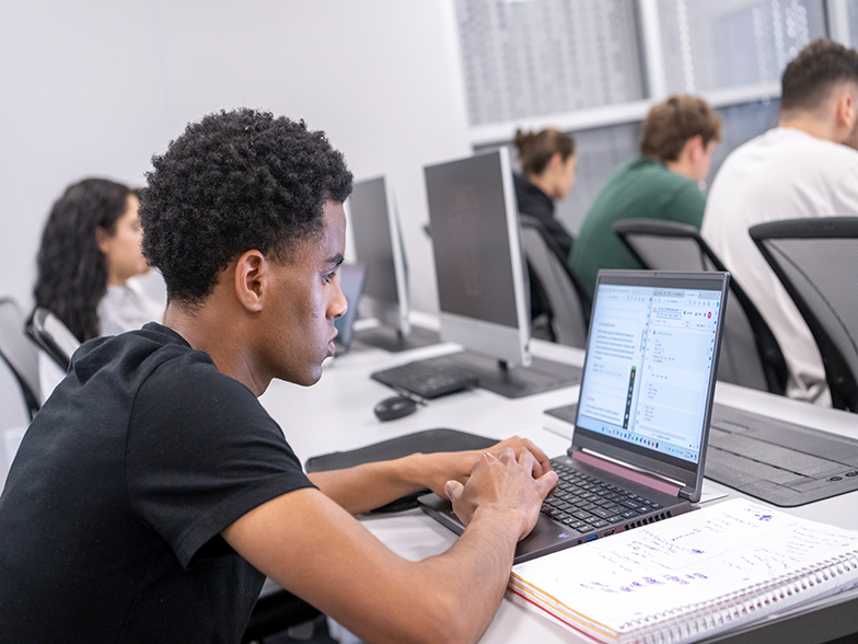 Three students sitting together and working on their laptops
