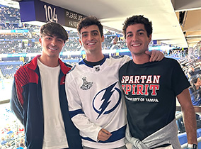 Three students at a Tampa Bay Lightning game.