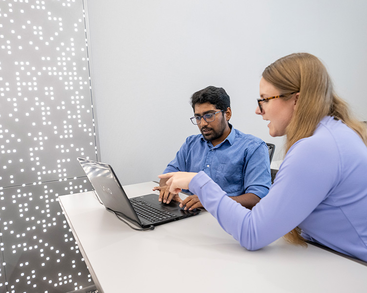 Professor and student talking over a laptop.