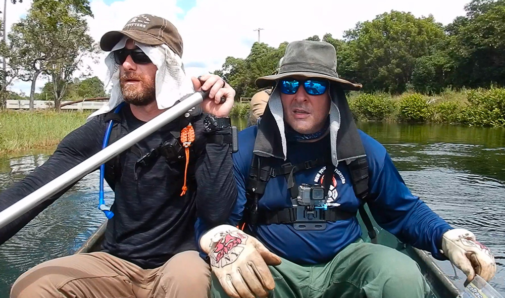 two min sitting in a boat on river
