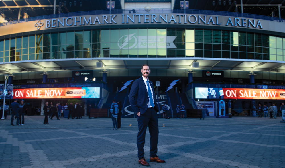 Man standing in front of Benchmark International Arena outdoors