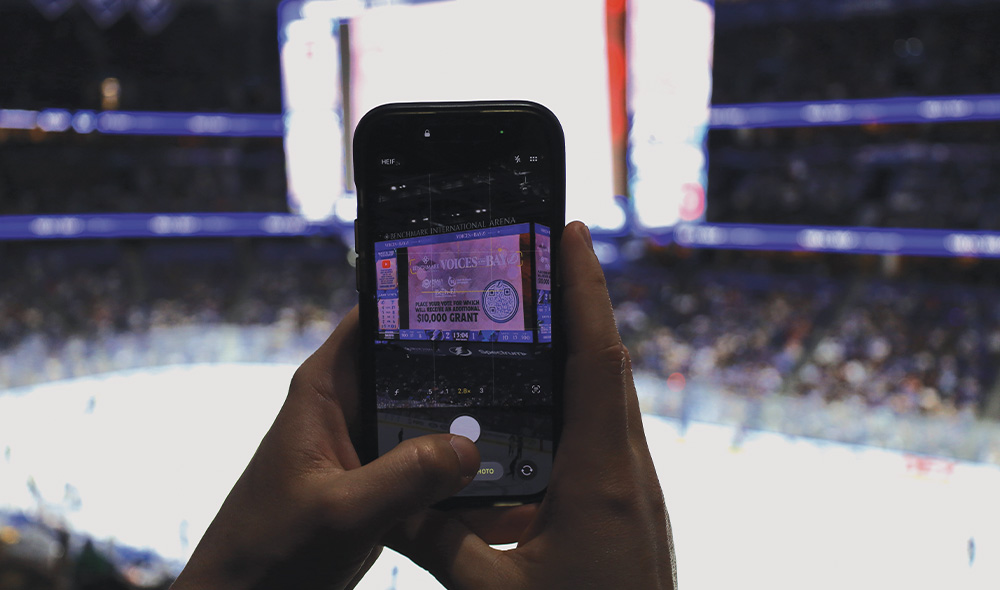 Someone holding phone scanning QR code on jumbotron