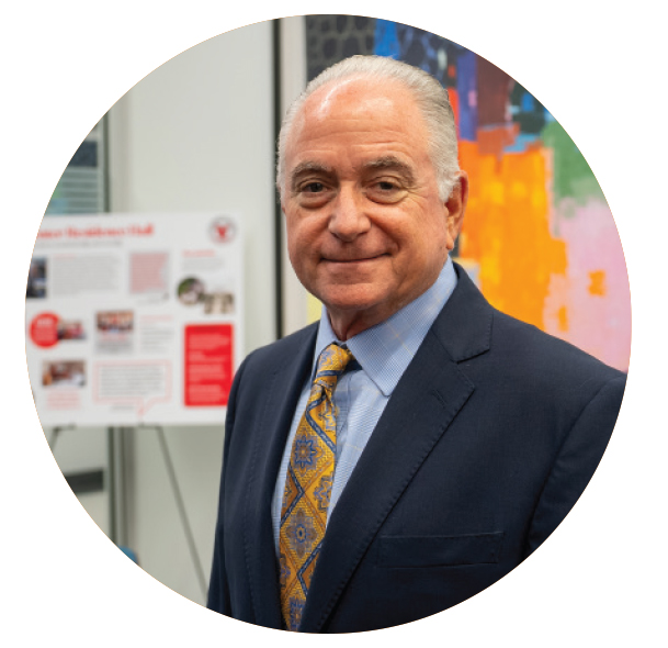 A MAN IN A SUIT LOOKS AT THE CAMERA