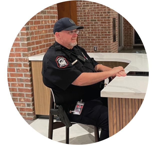 A CAMPUS SAFETY OFFICER IS SEATED AT A DESK