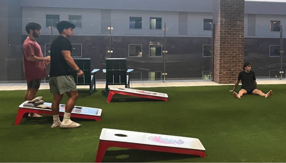 YOUNG MEN PLAYING CORN HOLE
