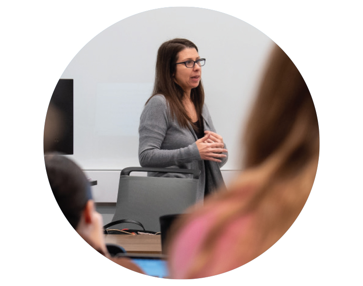 A WOMAN STANDS AT THE FRONT OF A ROOM