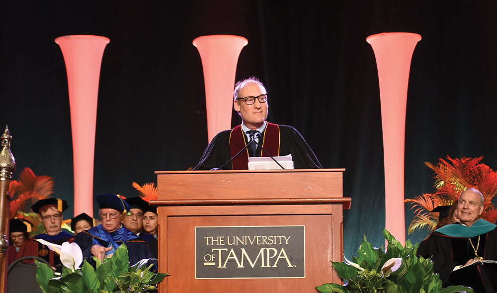 A MAN STANDS AT A LECTURN