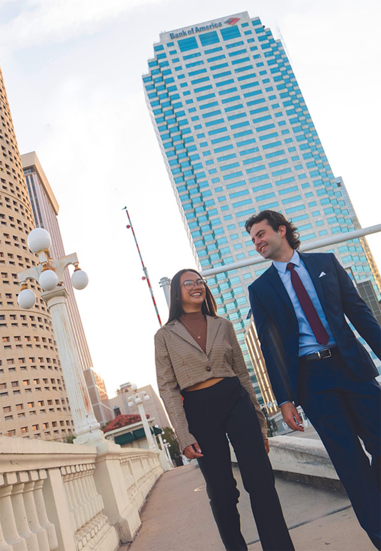 students walking by river with view of downtown Tampa