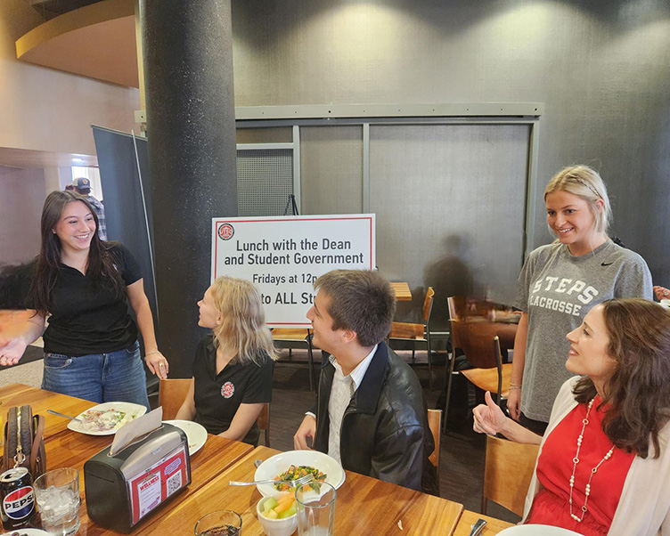 SG President talking with people at lunch in the Vaughn Center.