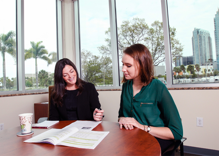 two people sitting at a table talking Financial Wellness Logo