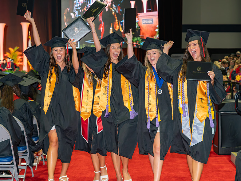 Graduates with their diplomas at commencement