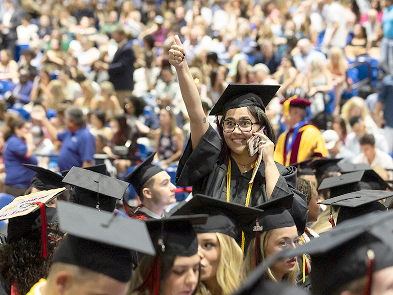 Graduates waving to a family member in the crowd