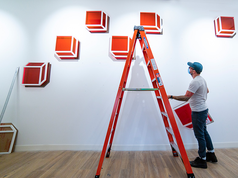 A man assembling an art display.