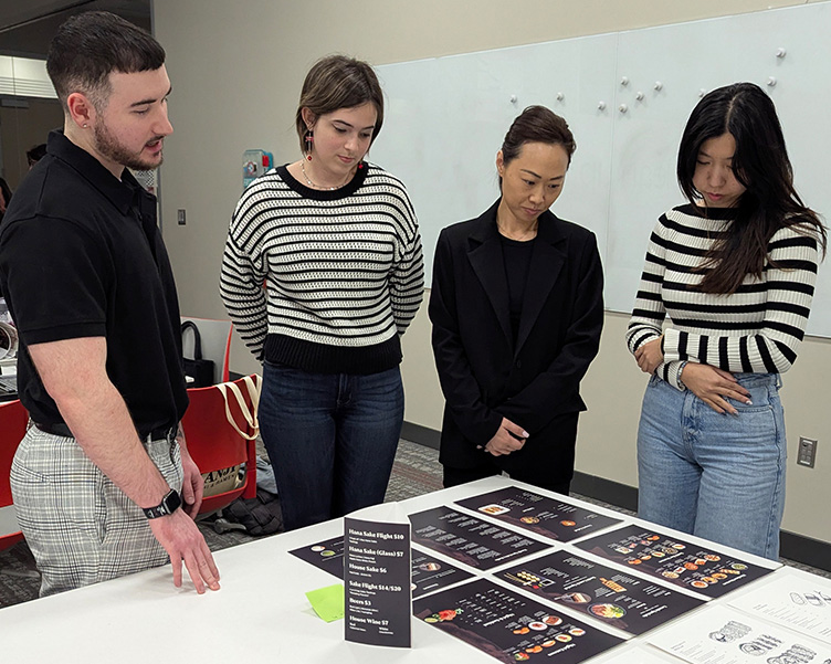 Professor working with two students in a classroom.