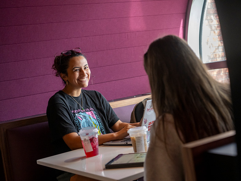 Students talking at a table. 