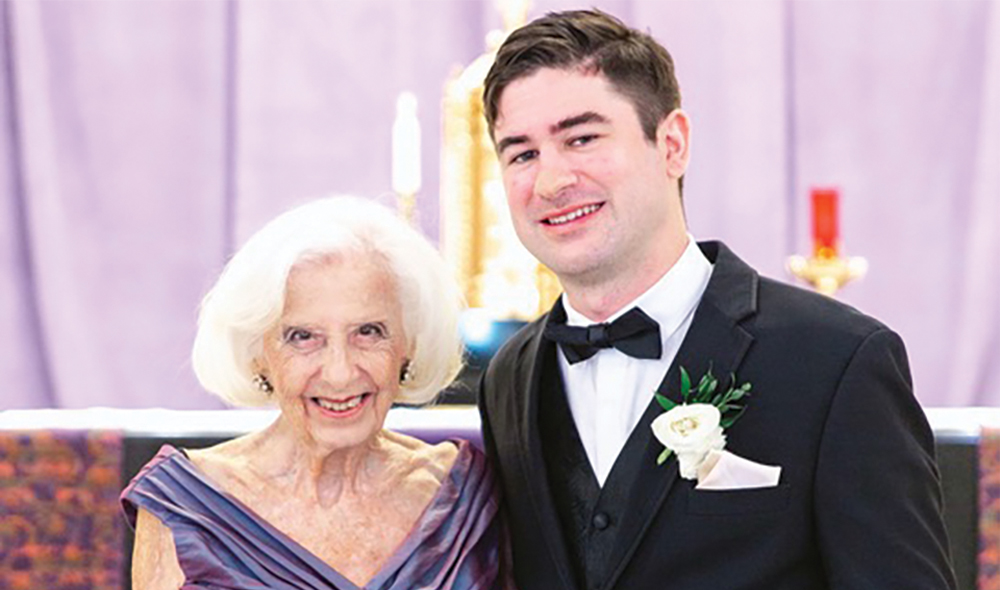 A WOMAN IN A FORMAL GOWN STANDS NEXT TO A MAN IN A TUXEDO