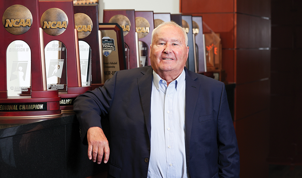 a man stands in front of a trophy case