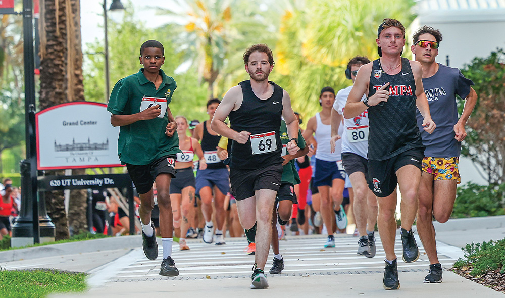A group of runners wearing race numbers pinned to their shirts