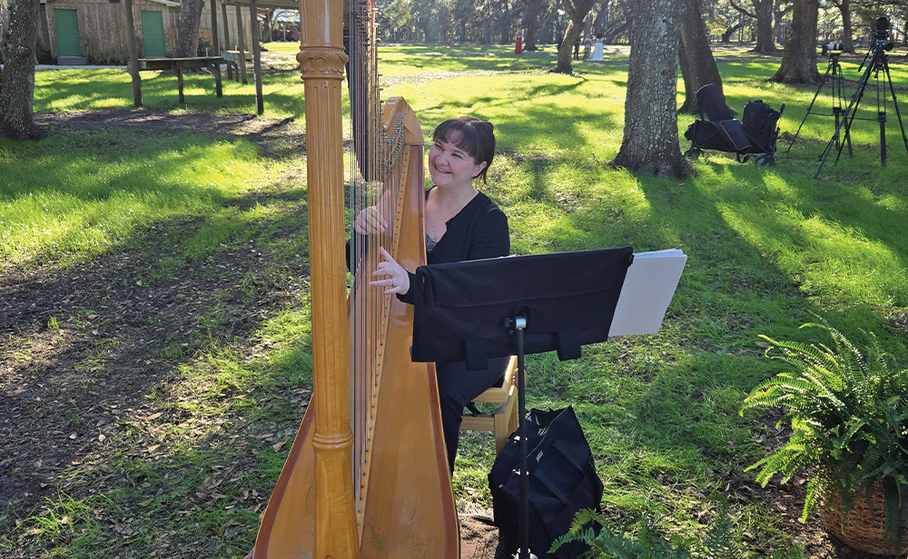 A WOMAN IS PLAYING A HARP OUTSIDE