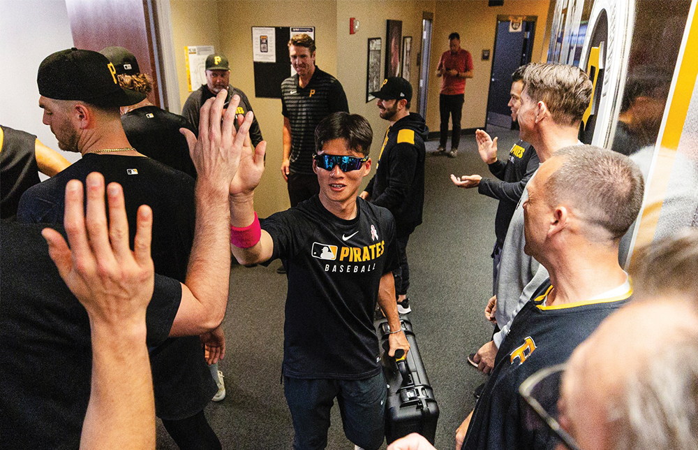 A man wearing sunglasses gives a high-five to another person