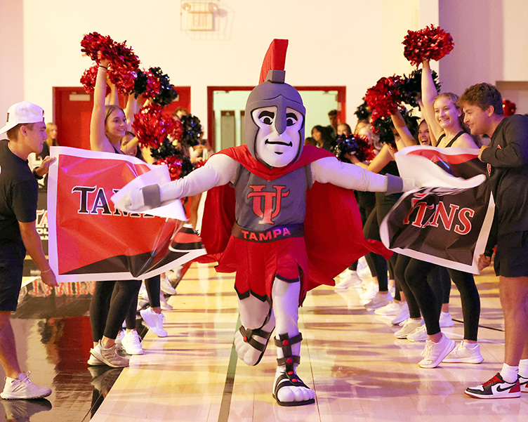Sparty the mascot running through a pep rally