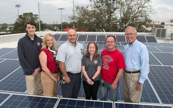 People standing by solar panels