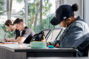 Students taking a test in a classroom with tall windows