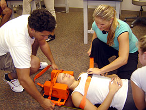 Students stabilizing another student's neck Students stabilizing another student's neck