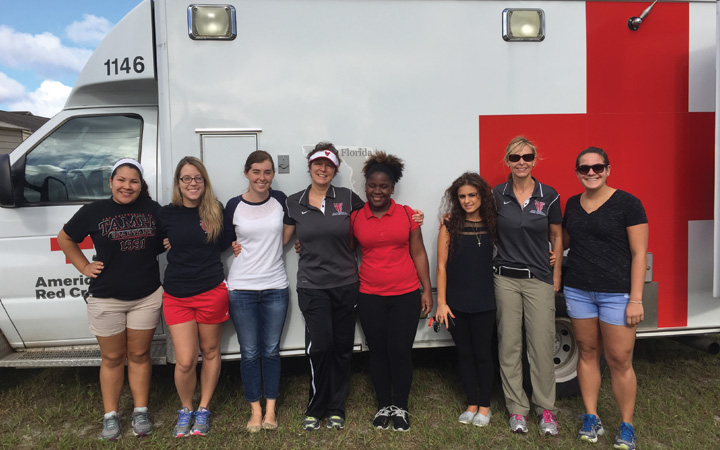 Students and professors standing in front of the American Red Cross vehicle