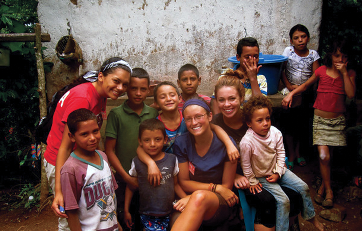 A group of UT students sits with a group of local Hondurans.