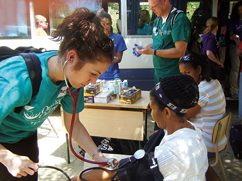 UT nursing student checks the pulse of a patient in the Dominican Republic with her stethoscope.