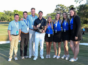 Students holding trophies on a golf course