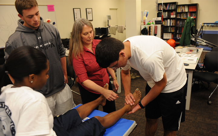 Student flexing another student's foot