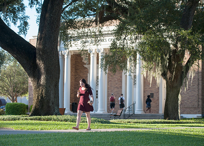 Student walking in front of the Sykes College of Business