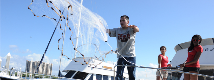 Student casting a net into water