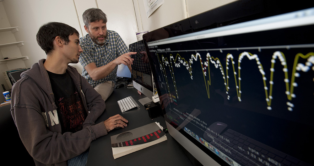 Professor and student looking at a monitor