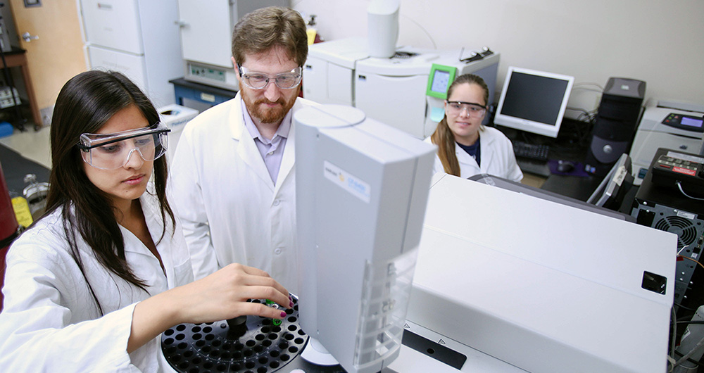 2 students and their professor in a science lab