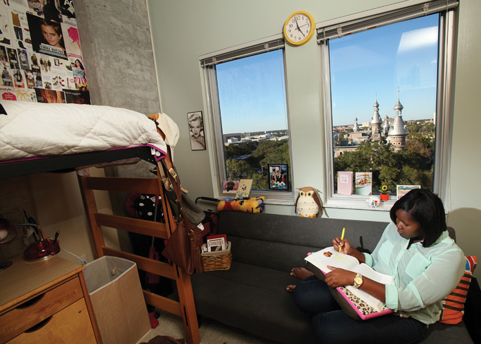 A student sitting in her bedroom in Urso Hall