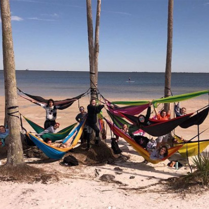 people in hammocks at the beach 