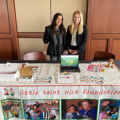 little saint nick foundation members standing behind table 