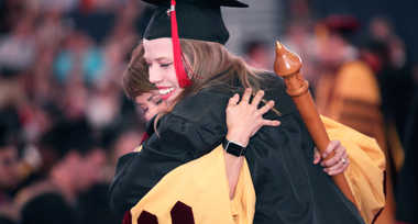 A new UT graduate hugs a professor at commencement