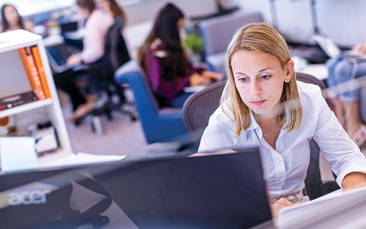 Student sitting in an office,using her computer