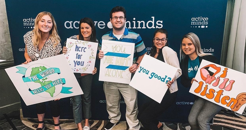 students holding up inspirational signs 