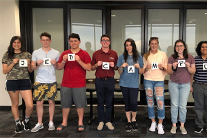 Students holding up signs that spell JED Campus